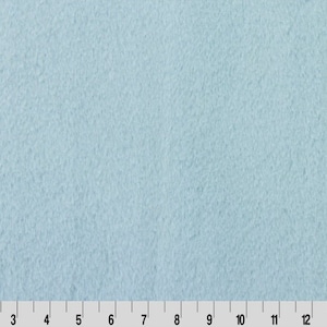 May include: A light blue fleece fabric with a soft, fuzzy texture.