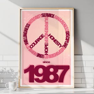 May include: A framed poster with a peace symbol design. The symbol is composed of words like "Courage" and "Honesty" in a dark red hue, set against a gradient pink background. The text "since 1987" is also visible.