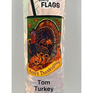May include: A colourful garden flag with a Thanksgiving theme. The flag features a turkey wearing a pilgrim hat, surrounded by autumn leaves, pumpkins, and sunflowers. The text "Happy Thanksgiving" is written on a yellow banner.