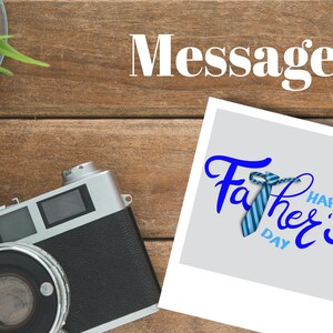 May include: A white photo frame with a blue and white striped tie and the text "Happy Father's Day" in blue lettering. The photo frame is on a wooden surface.