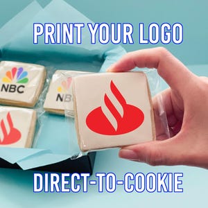 May include: Square cookies with company logos are packaged in a black box with blue tissue paper. One cookie is held in a hand. The text "PRINT YOUR LOGO" and "DIRECT-TO-COOKIE" are displayed.