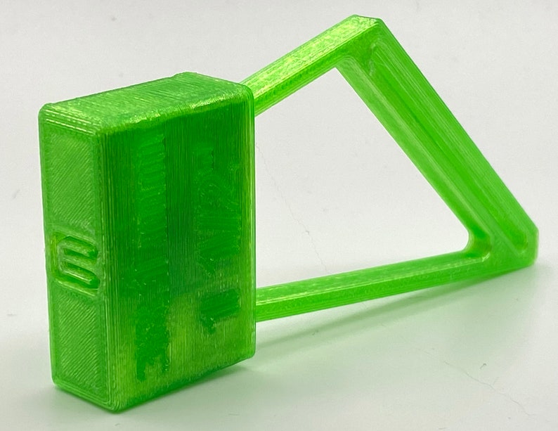 May include: A bright green plastic seal with a rectangular tag and a triangular loop. The tag has the text "SECURITY SEAL" printed on it.
