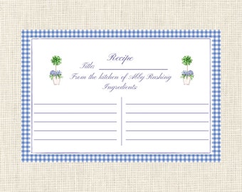 May include: A blue and white gingham recipe card with a white background. The card has a title section, an ingredients section, and a blank space for writing the recipe. The card is decorated with two small drawings of potted plants with green leaves and blue flowers.