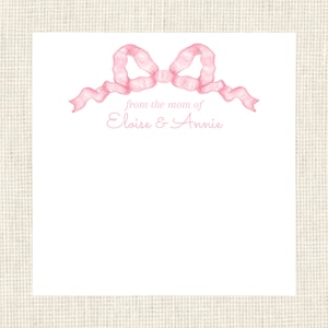 May include: A white card with a pink ribbon bow at the top. The text "from the mom of Eloise & Annie" is printed in pink below the bow.