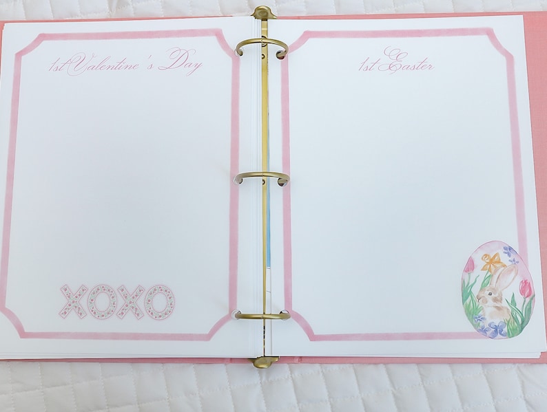 May include: A pink binder with two pages open. The left page has the text "1st Valentine's Day" and the text "XOXO" in pink. The right page has the text "1st Easter" and a drawing of a bunny in an egg.