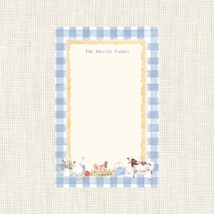 May include: A rectangular notepad featuring a blue and white gingham border and a cream-colored center. The text The Graves Family is printed at the top. The bottom edge displays watercolor illustrations of a goose, a hen, and a cow.
