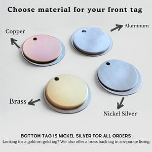 May include: Four circular metal tags arranged for material selection. Labels indicate Copper, Aluminum, Brass, and Nickel Silver. Text reads: Choose material for your front tag. BOTTOM TAG IS NICKEL SILVER FOR ALL ORDERS. Looking for a gold-on-gold tag?