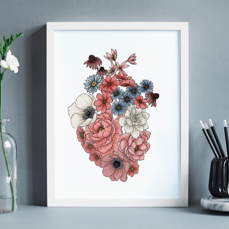 May include: A white frame with a print of a heart-shaped arrangement of pink, red, and blue flowers. The flowers are drawn in a detailed, realistic style.