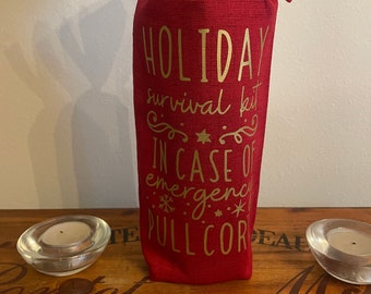 Bolsa de regalo navideña de vino tinto con letras doradas