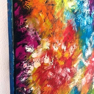 May include: Abstract painting with thick brushstrokes in vibrant colors. The artwork features a mix of orange, yellow, red, blue, and purple hues. The canvas has a blue border and the artist's signature, "MargoArtPanther", is visible.