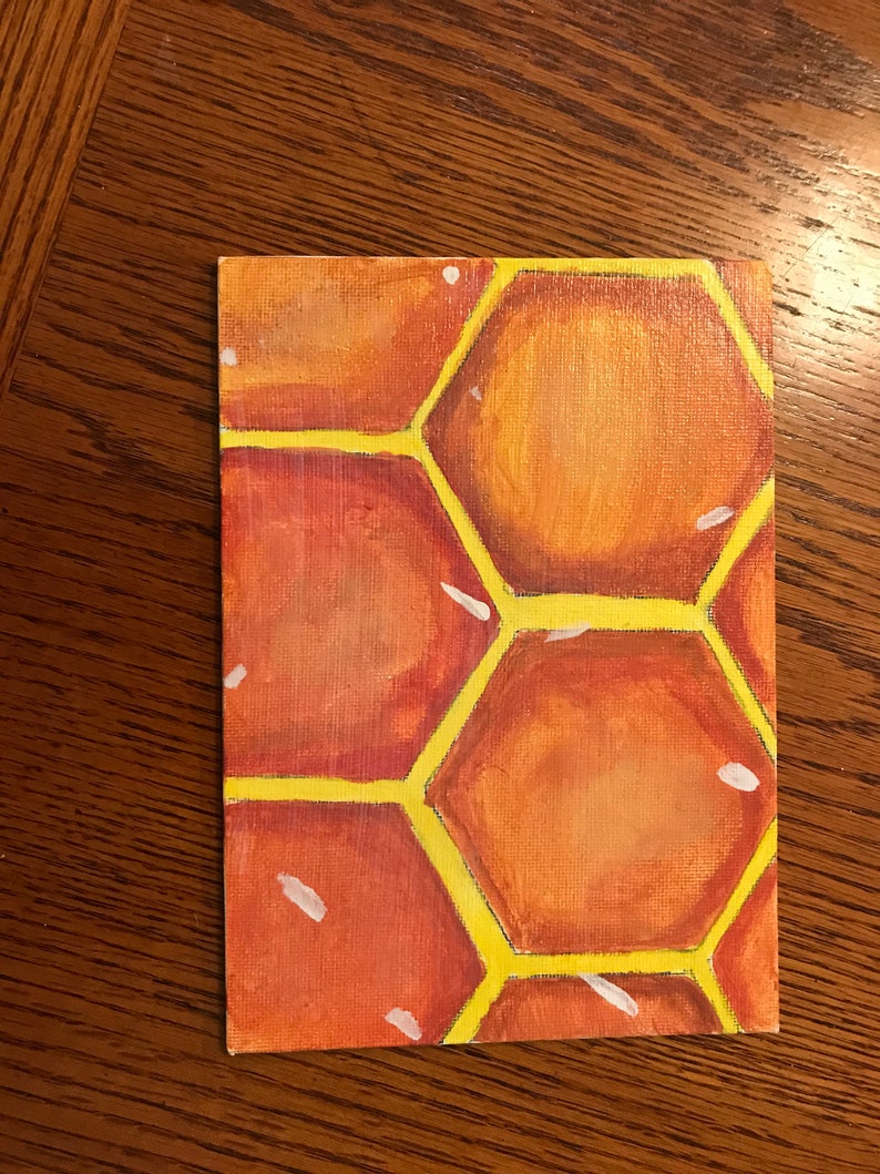 Puede incluir: Un primer plano de una pintura que representa un patr&oacute;n de panal. El panal est&aacute; pintado en tonos de naranja, amarillo y blanco.