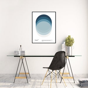 May include: A black framed poster with a white background and a blue and gray circle design. The poster is titled "Shapes" and is hanging on a white wall above a glass-top desk with a black chair.