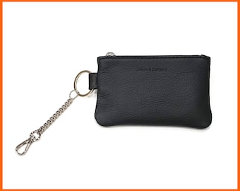 May include: A black leather key chain with a silver chain and a small black leather pouch with the text "Jassenia & Company" embossed on the front.