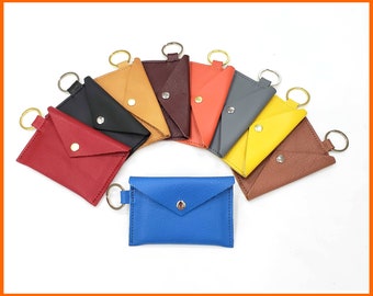 May include: Assortment of eight leather keychains in various colors, including red, blue, brown, yellow, orange, and gray. Each keychain has a metal ring and a small flap.