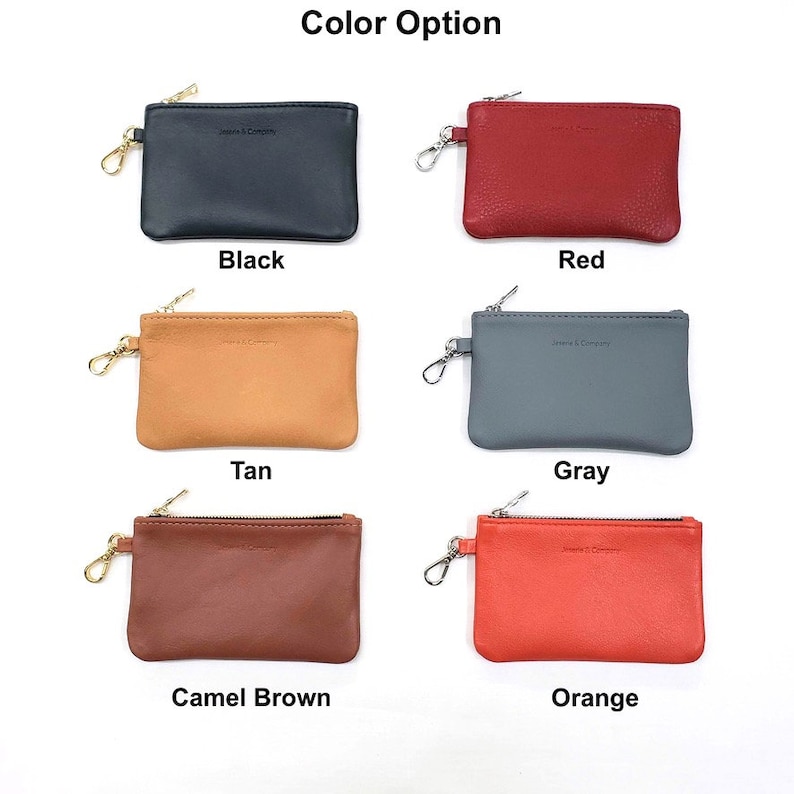 May include: Six leather coin purses with zipper closures and a metal ring. The purses are in the colors black, red, tan, gray, camel brown, and orange.