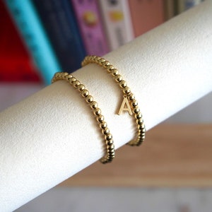Pulseira elástica com contas preenchidas com ouro 18k de 4 mm com ou sem pingente de letra