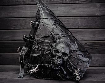 May include: Black leather motorcycle saddlebag with a skull design and metal buckles.