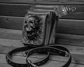 May include: A black leather thigh holster with a skull design. The holster has a zippered pocket and a strap with a buckle.