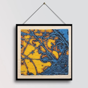 May include: A square cross-stitch embroidery piece framed in a black border with a hanging wire. The design features a vibrant yellow background overlaid with intricate, dark blue linear patterns that create a complex, web-like abstract composition.