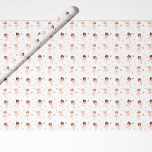 May include: A roll of wrapping paper and a flat sheet of wrapping paper featuring a repeating pattern of illustrated ballerinas in pink tutus, interspersed with small gold stars and dots on a white background, creating a delicate design.