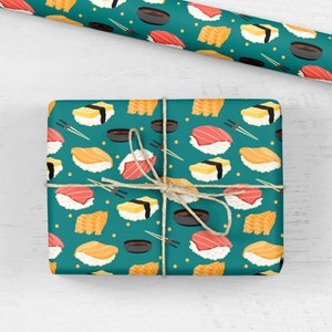 May include: Teal blue wrapping paper with a repeating pattern of sushi rolls, soy sauce dishes, and chopsticks. The sushi rolls are filled with salmon, tuna, and egg.