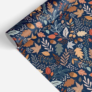 Puede incluir: Papel de regalo azul con un patr&oacute;n repetitivo de hojas, bellotas y bayas en tonos marrones, naranjas y verdes.