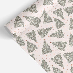 May include: A roll of wrapping paper featuring a repeating pattern of stylized evergreen trees in shades of sage green and dark green on a pale pink background, accented with small orange stars scattered throughout the design.