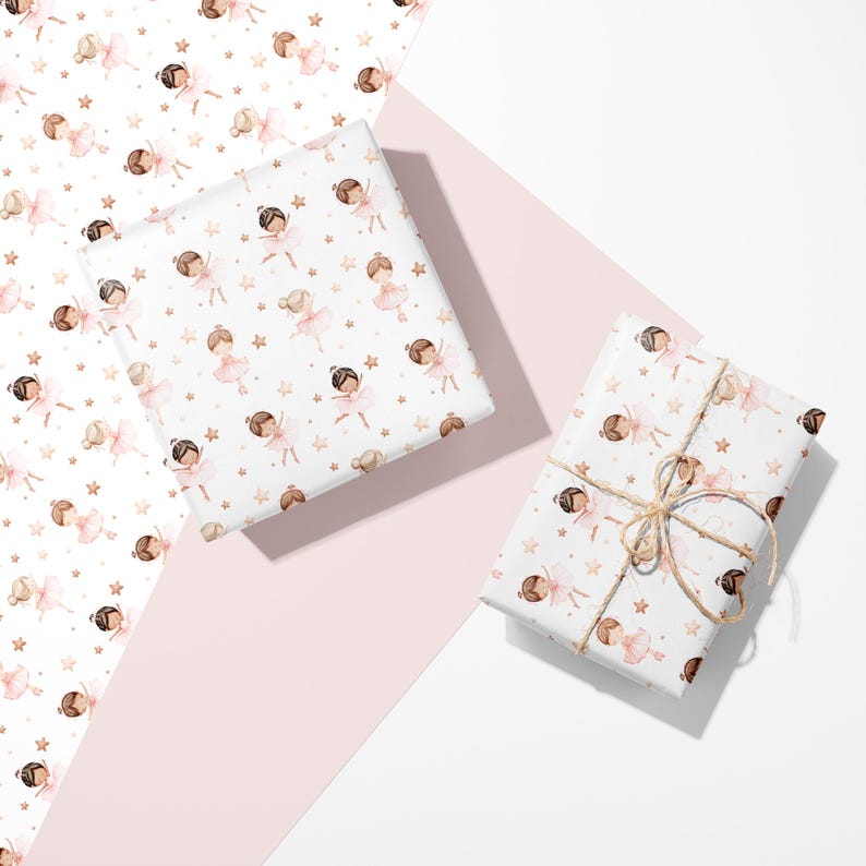 May include: Wrapping paper featuring a repeating watercolor pattern of ballerinas in pink tutus and small gold stars on a white background. One square package is wrapped in the paper, and a rectangular package is tied with thin brown twine.