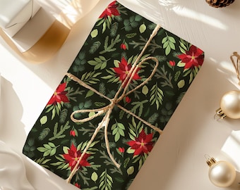 May include: A wrapped gift with a dark green background featuring a pattern of red poinsettias, green leaves, and sprigs. The gift is tied with twine and is surrounded by Christmas ornaments and pinecones.