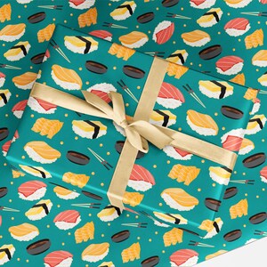 May include: Teal blue wrapping paper with a repeating pattern of sushi rolls. The sushi rolls are filled with different colors of fish and vegetables. The paper is tied with a gold ribbon.