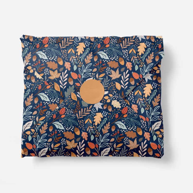 Puede incluir: Un sobre azul con una pegatina circular de papel marr&oacute;n. El sobre est&aacute; decorado con un patr&oacute;n de hojas, bellotas y bayas en tonos naranja, rojo y verde.