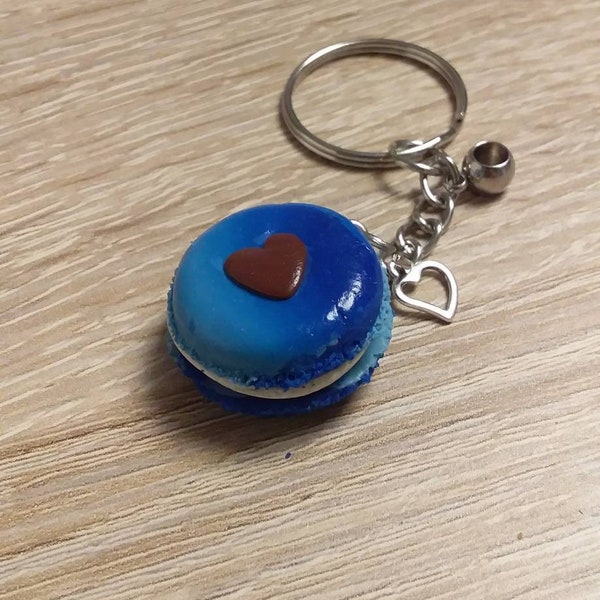 1 porte clés- macaron bicolore bleu foncé et bleu clair monté sur un support argenté classique orné d'une perle et d'un coeur assorti.