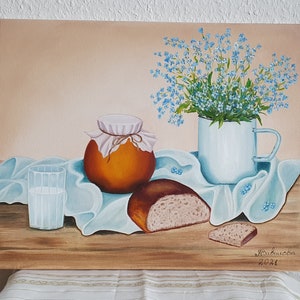 Peut inclure: Une peinture de nature morte représentant un pot brun avec un couvercle blanc, un verre de lait, deux morceaux de pain, une tasse bleue et blanche remplie de fleurs bleues myosotis et un tissu bleu sur une table en bois. La peinture est signée "Maricucica 2021".