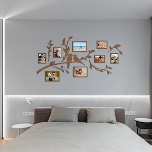 May include: A wooden wall decoration featuring a tree branch design with multiple photo frames. The frames are arranged in a whimsical pattern and feature various family photos. The tree branch design is a unique and stylish way to display cherished memories.