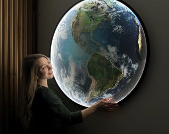May include: A round, illuminated wall art piece depicting Earth. The artwork features a detailed map of the continents and oceans, with a bright, glowing edge. The piece is set against a dark background, creating a striking visual effect.