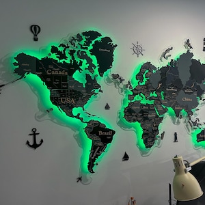 Pode incluir: Um mapa-múndi de madeira com retroiluminação LED verde, montado numa parede branca. O mapa apresenta nomes de países e elementos náuticos decorativos como uma âncora e um leme. Os continentes são escuros, com iluminação verde brilhante.