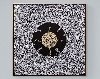 Peut inclure: Œuvre d'art abstraite dans un cadre doré. L'œuvre présente un fond noir avec un motif circulaire doré central et une écriture blanche. Elle est accrochée à un mur blanc au-dessus d'un canapé gris avec un coussin à motifs. Une lampe blanche et une table de chevet sont également visibles.