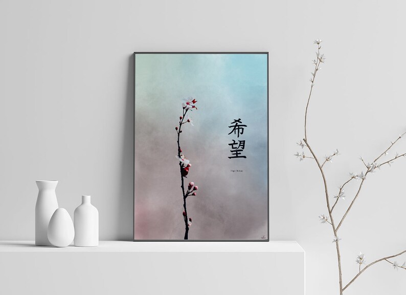 May include: A framed print with a watercolor-style background of blue and pink hues. A single branch with white blossoms and red buds is in the center of the print. The Japanese characters "春 望" are written in black ink on the right side of the print. The text "Spring Hope" is written in smaller font below the characters.