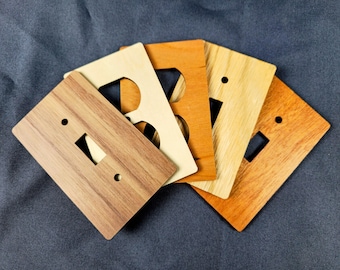 Placas para interruptores y enchufes de madera cortadas con láser, cubiertas con vetas de madera natural, configuraciones personalizadas disponibles.