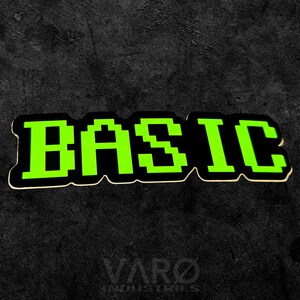 May include: A sticker featuring the word BASIC in a bright lime green pixelated font with a thick black outline. The letters have a blocky, digital appearance, and the entire design is set against a dark, textured background with the text VARO INDUSTRIES.