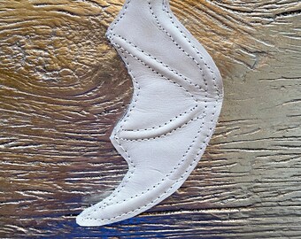 May include: White leather bat wing keychain with a silver metal ring and clip.