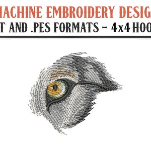 Puede incluir: Diseño de bordado a máquina de un ojo de animal gris y blanco con un iris amarillo y verde. El diseño está en formatos .DST y .PES y es para aros de 4x4.