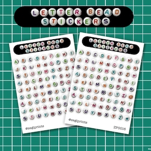 May include: Two sheets of letter bead stickers are displayed on a green grid background. Each sticker sheet has a black header with the words "LETTER BEAD STICKERS". The stickers are round, with colorful letters.