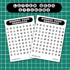 May include: Two sheets of letter bead stickers with a black banner at the top that reads "LETTER BEAD STICKERS". Each sheet has the alphabet in a circular bead design. The stickers are on a green grid background.