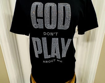 May include: Black t-shirt with a rhinestone design that reads "GOD DON'T PLAY ABOUT ME".