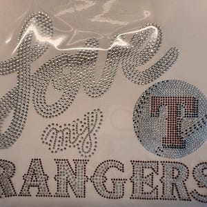 May include: A white ceramic mug with a black handle and the text "But First, Coffee" in a black, handwritten-style font. The mug is on a white surface.