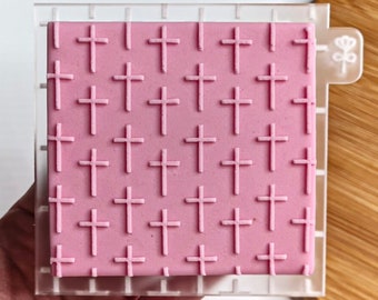 May include: A clear plastic sheet with a pink silicone insert. The silicone insert has a repeating pattern of small crosses.