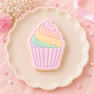 May include: A cupcake-shaped sugar biscuit decorated with pastel icing. The frosting features swirls of pink, peach, yellow, and mint green, while the cupcake liner is detailed with vertical stripes in a soft lavender shade of icing.