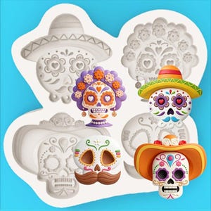 Puede incluir: Un molde de silicona blanco con cuatro cavidades distintas en forma de calaveras de azúcar, incluyendo dos con sombreros y una con tocado floral. Tres figuras de calaveras de azúcar coloridas se muestran frente al molde como referencia.