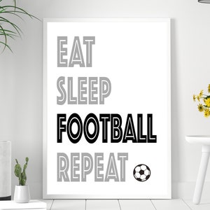 May include: Black and white print with the text "Eat Sleep Football Repeat" and a black and white soccer ball.